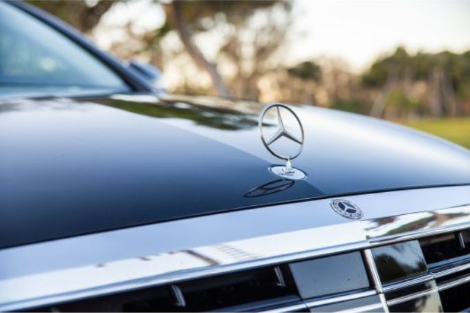 Front view of a black Mercedes car with a close-up of the Mercedes star emblem, ready for chauffeur service to La Duquesa.